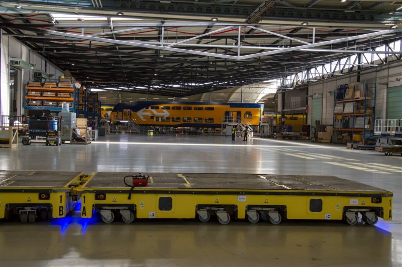 Het transport van de bakken naar de werkstations vindt plaats met deze radiografisch bestuurbare lorries