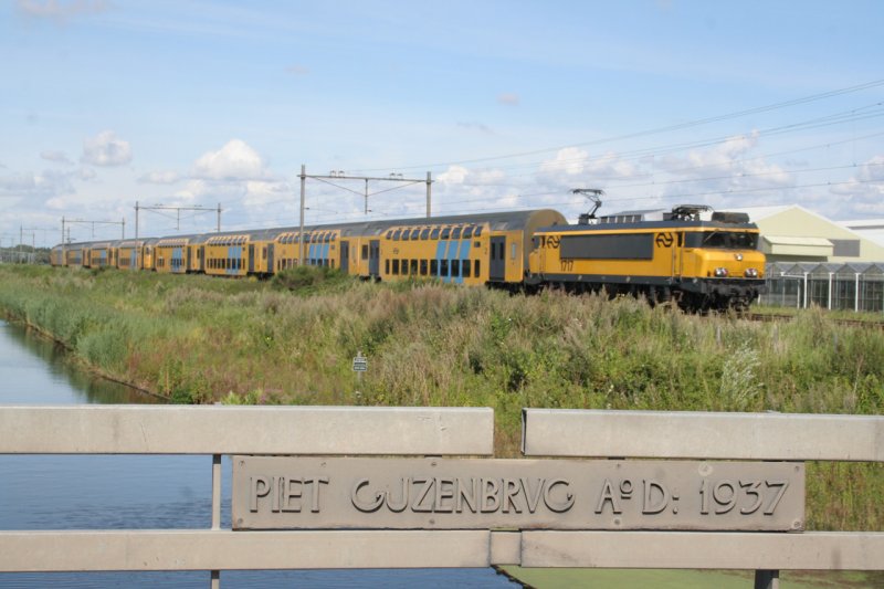 Een lange stam met DD-AR die getrokken wordt door de 1717 passeert de Piet Gijzenbrug tussen Haarlem en Amsterdam Centraal. (Rechten: Willem90)